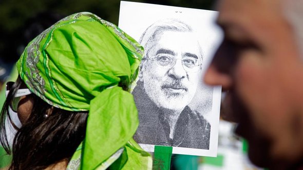 Green Revolution activists hold up a poster of Mir-Hossein Moussavi, leader of the movement (photo: AP) Green Revolution activists hold up a poster of Mir-Hossein Moussavi, leader of the movement (photo: AP)